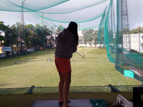 Garota na área de treinos de tacadas longas do Embrase Golf Center (Andrei Spinassé/Esportividade)